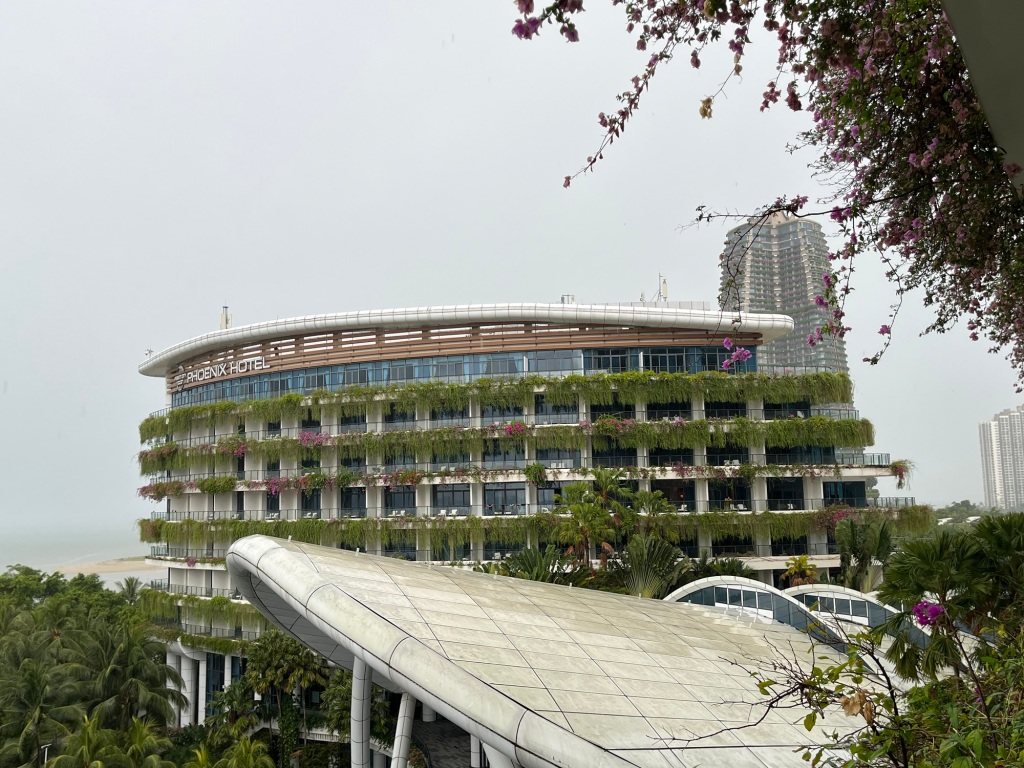 Image of hotel with plants at the balcony and sky at the background
